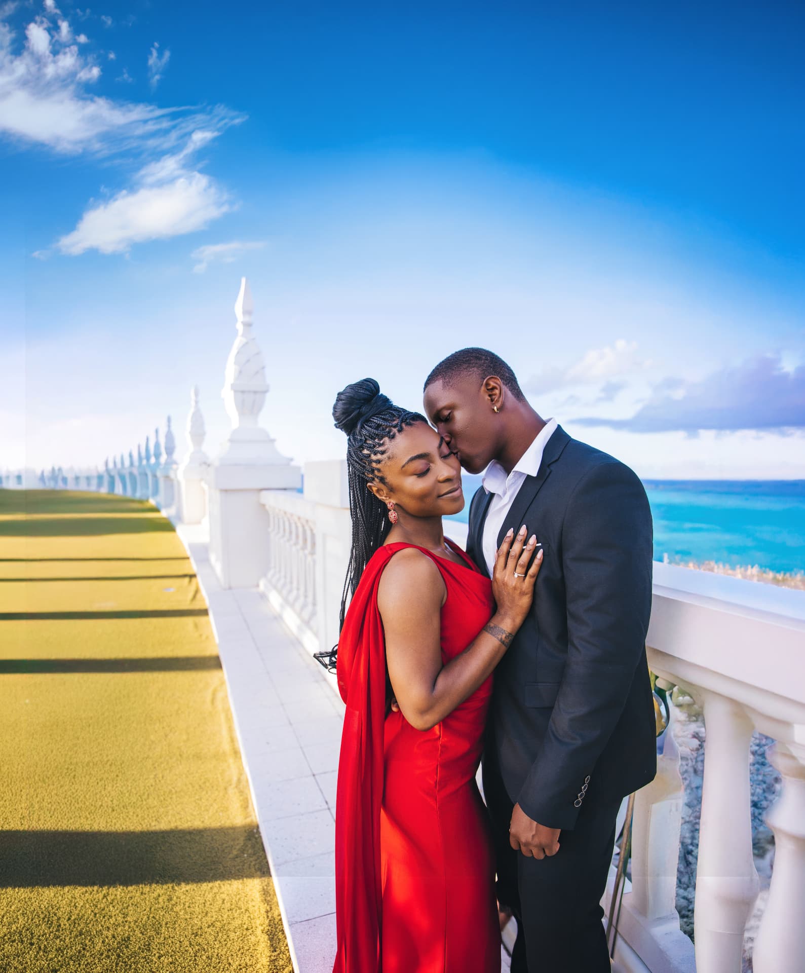 Couple photographed by Platinum Photography on a white-columned seaside terrace in Nassau